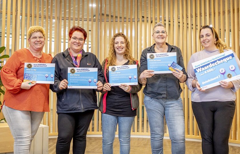 5-tal lachende schoonmaakmedewerkers die hun oorkonde van de Gom Uitblinker voor zich houden