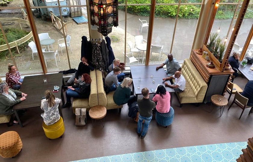 kijkend van boven op een groep rayonleiders die in een zaal van Diergaarde Blijdorp zitten