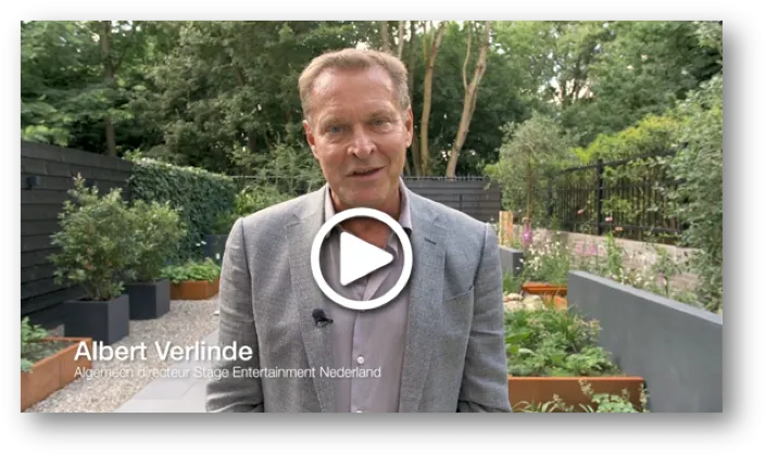 Albert Verlinde, algemeen directeur van Stage Entertainment Nederland, spreekt in een video vanuit een tuin met planten en bomen.