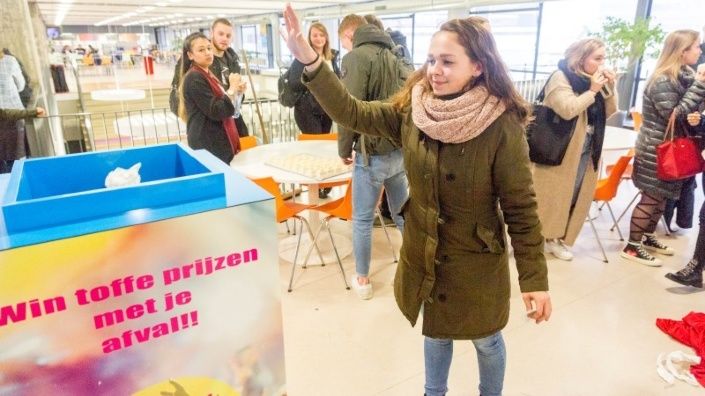 Een jonge vrouw die haar afval weggooit in de trash roulette 