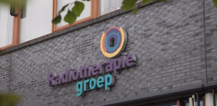 Gevel met logo en naam van de Radiotherapiegroep op een grijs gebouw.