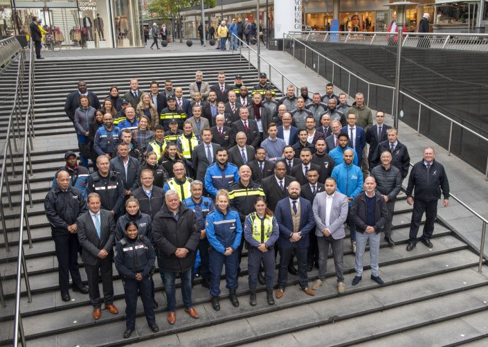 Een groep mensen staan geposeerd op de trap van de Koopgoot in Rotterdam.