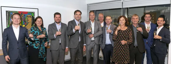 Bestuurders en betrokkenen van Gom en Degenaar Gevelonderhoud toosten met champagne op de overname.