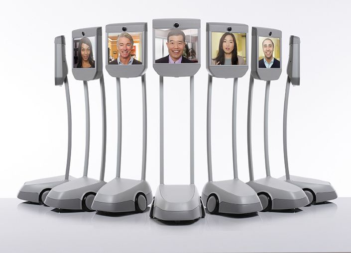 Zeven staande schermen staan op een verrijdbare basis. Op de schermen zijn gezichten afgebeeld zoals een conference call.
