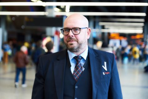 Mannelijke beveiliger in uniform loopt in de centrale hal van de Jaarbeurs Utrecht.