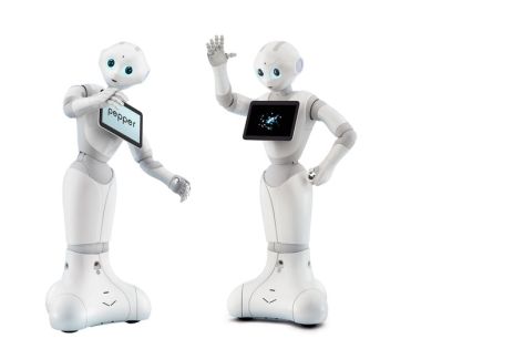 Drie witte robots met blauwe ogen genaamd Pepper, zij hebben een iPad voorop voor informatie op te lezen.