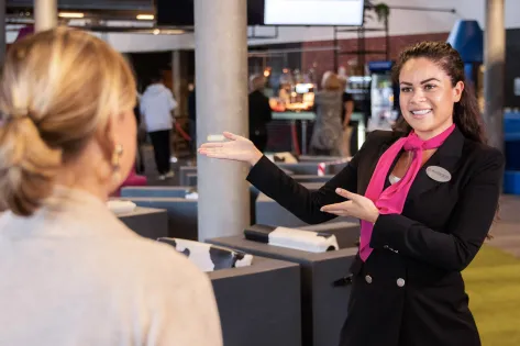 Medewerkster van Embrace wijst vrouwelijke bezoeker de weg.