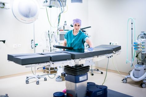 Een medewerkster van Gom Zorg staat met een doekje de operatietafel schoon te maken