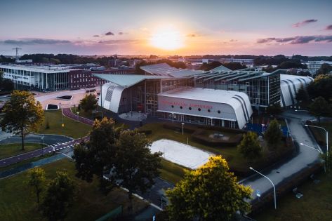 Een luchtfoto van Hanzehogeschool met een opkomende zon op de achtergrond