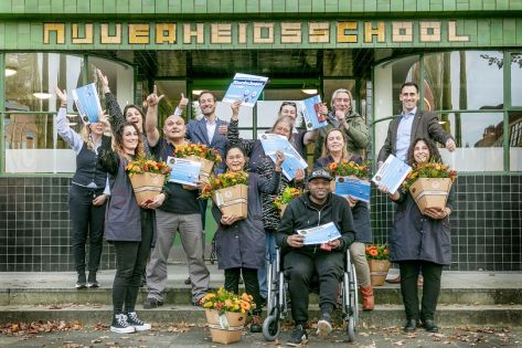 het team Wiebenga van Hanzehogeschool staat voor het pand te juichen met bloemen en hun certificaat