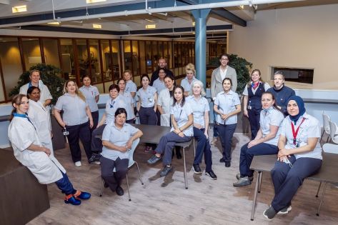 het schoonmaakteam van Gom Zorg bij Deventer Ziekenhuis zit/staat bij elkaar en kijken in de camera