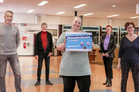 Gom Uitblinker Esmeralda houdt trots de waardencheque omhoog met om haar heen haar leidinggevenden.