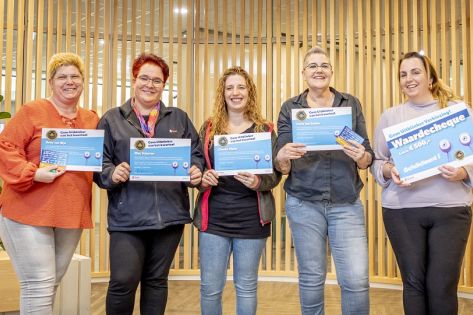 5-tal lachende schoonmaakmedewerkers die hun oorkonde van de Gom Uitblinker voor zich houden