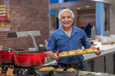 chef poseert glimlachend met een plateau broodjes