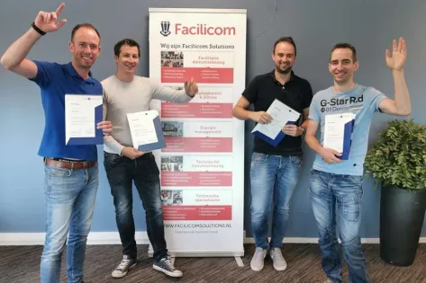 Vier medewerkers van Facilicom Solutions poseren met hun certificaten na het behalen van de RVB-BOEI opleiding.