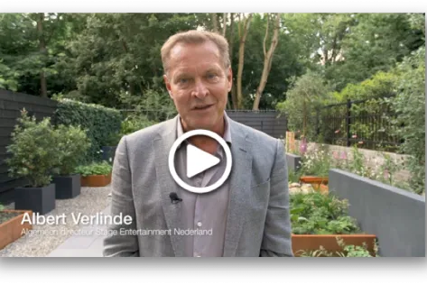Albert Verlinde, algemeen directeur van Stage Entertainment Nederland, spreekt in een video vanuit een tuin met planten en bomen.