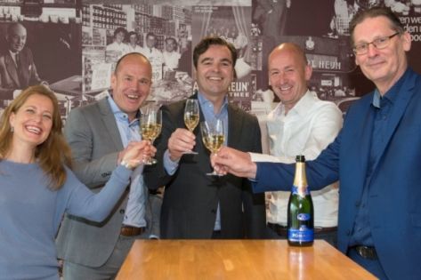 Een groepje van 5 personen proost met champagne na ondertekening contract