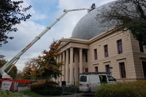 Medewerkers van Gom Specialistische Reiniging reinigen het dak en de koepel van Museum de Fundatie in Zwolle met behulp van een telescoophoogwerker.