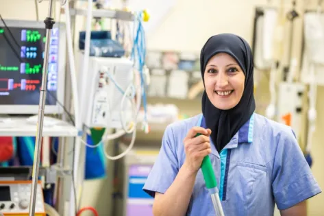 een portretfoto van Kafa el Akhras van Gom Zorg, gesitueerd in een ziekenhuiskamer met allerlei medisch apparatuur