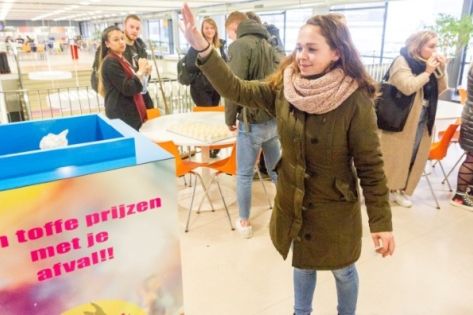 Een jonge vrouw die haar afval weggooit in de trash roulette 