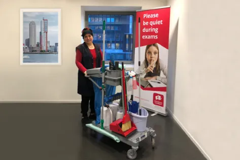 Schoonmaakmedewerker van Gom met een materiaalwagen gemaakt van tot 90% gerecycled plastic, onderdeel van de duurzame samenwerking met leverancier BOMA.