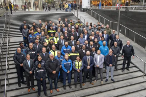 Een groep mensen staan geposeerd op de trap van de Koopgoot in Rotterdam.